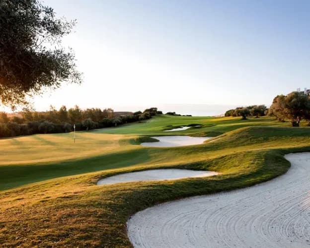 Championship golf course with manicured fairways and sand bunkers at golden hour, perfect for luxury golf holidays